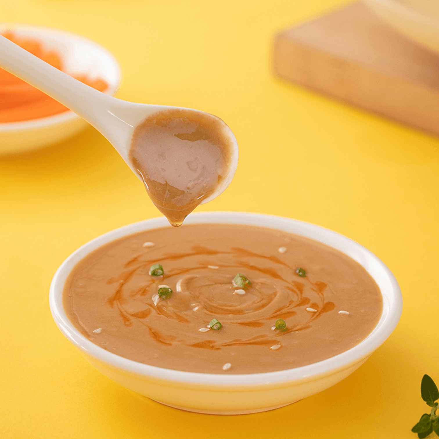 Spoonful of HAIDILAO Original Hot Pot Dipping Sauce with scallion and sesame