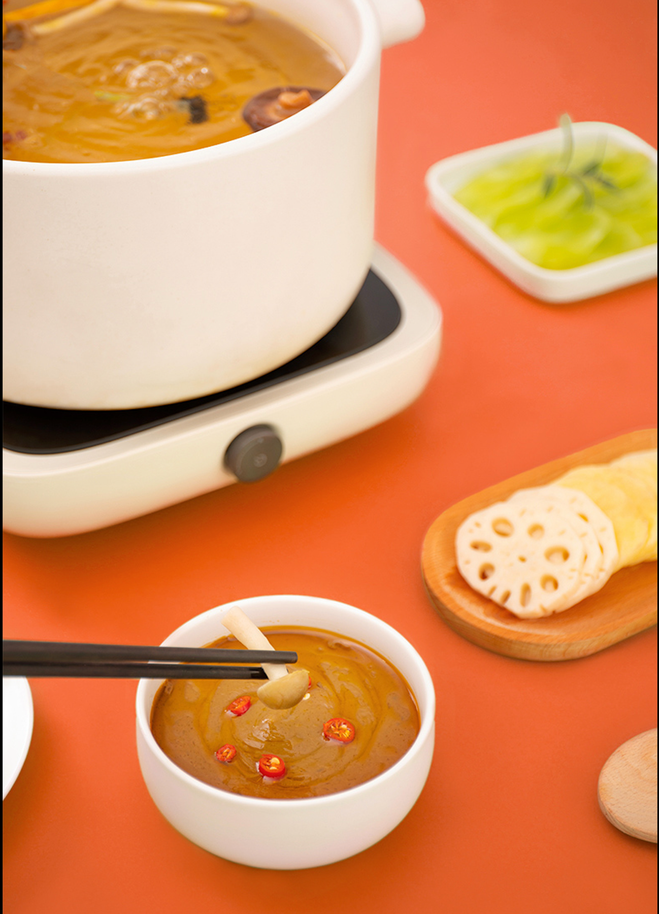 HAIDILAO Spicy Hot Pot Dipping Sauce served with hot pot broth, lotus root, and dried chilies