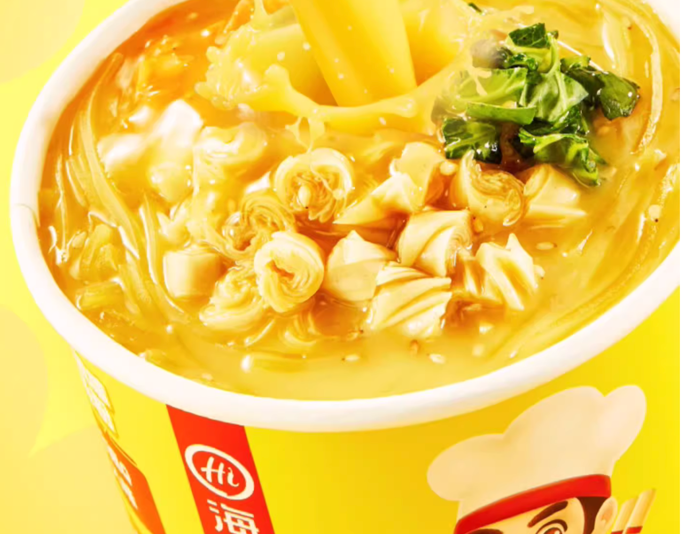 Close-up of golden sour soup vermicelli noodles with bamboo shoots and vegetables in a HAIDILAO cup