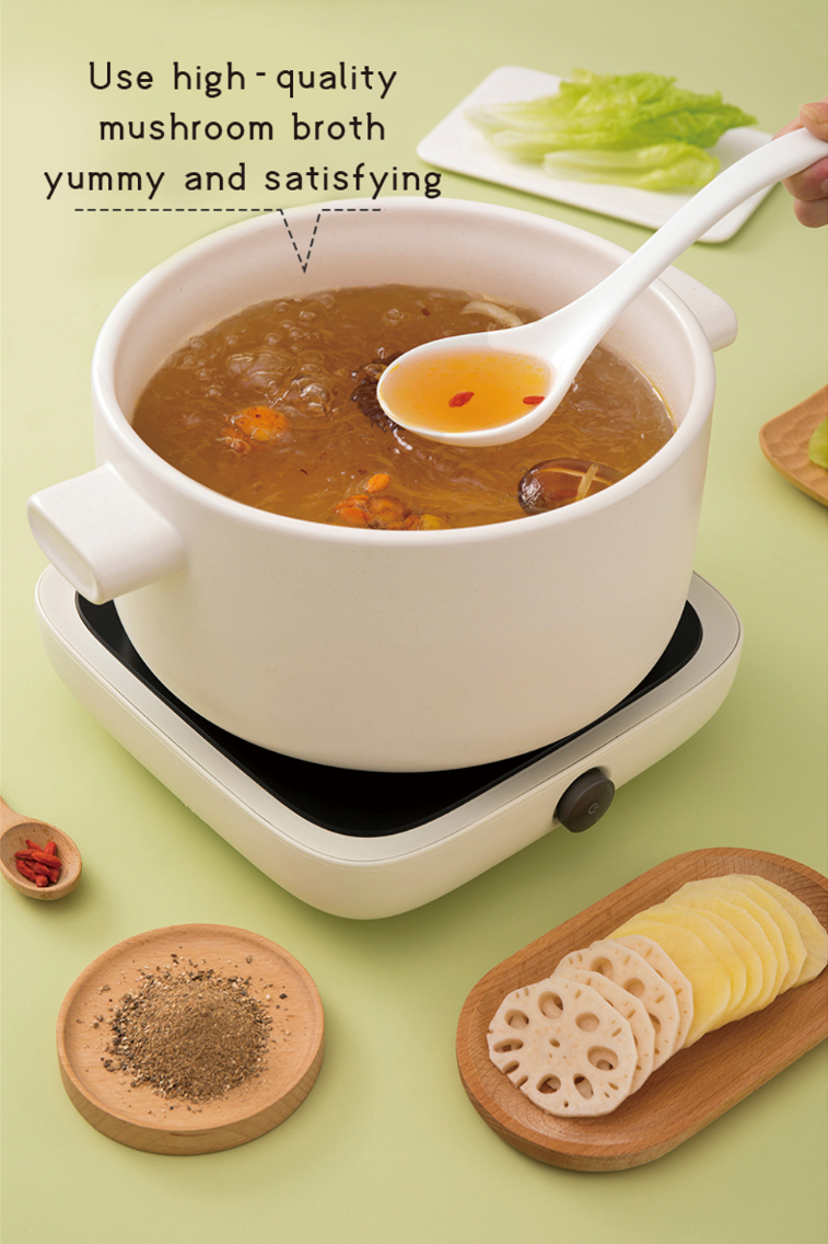 Bowl of HAIDILAO Mushroom Hot Pot broth with goji berries and mushrooms, served with lotus root and hot pot ingredients